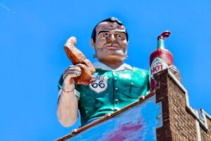 Muffler Man with a cigar, chicken wing and hot sauce